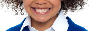 close-up image of the teeth of a grinning child, featured image for why do kids grind their teeth blog