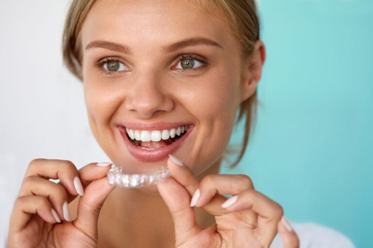 Smiling Woman With Beautiful Smile Using a teeth straightener